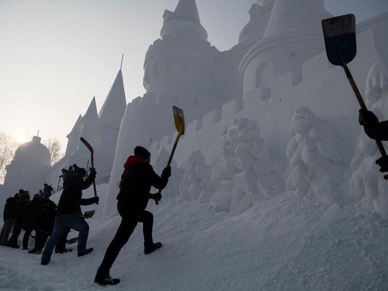 Workers apply the finishing touches to an ice sculpture ahead of the opening of the Harbin International Ice and Snow Festival in Harbin, in China's northeast Heilongjiang province on January 4, 2020. NOEL CELIS / AFP