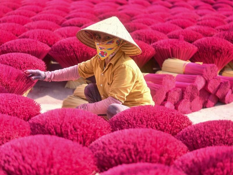 A Vietnamese woman collects dried incense sticks at a courtyard in Quang Phu Cau village on the outskirts of Hanoi on January 9, 2020 ahead of the upcoming Lunar New Year celebrations, referred to in Vietnam as Tet. Manan VATSYAYANA / AFP