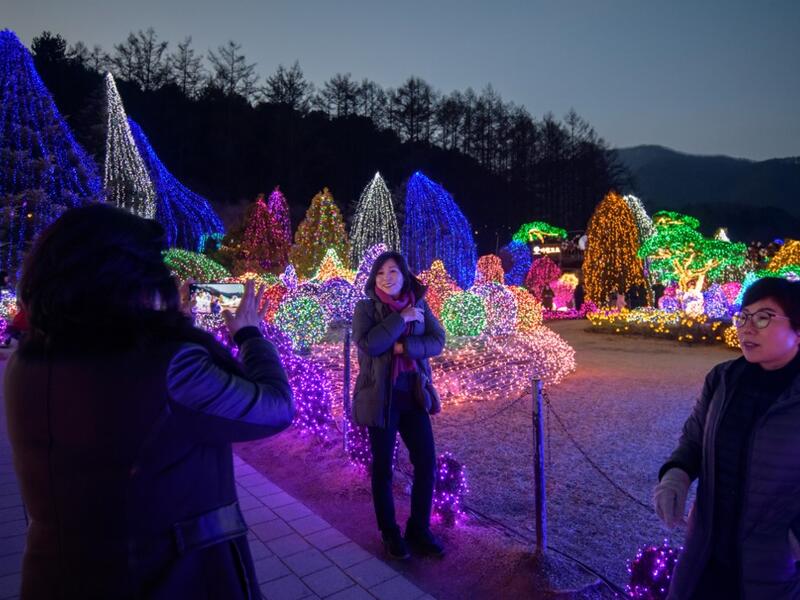 In a photo taken on January 11, 2020 visitors look at an annual light display at the 'Garden on Morning Calm', near Gapyeong, east of Seoul. Ed JONES / AFP