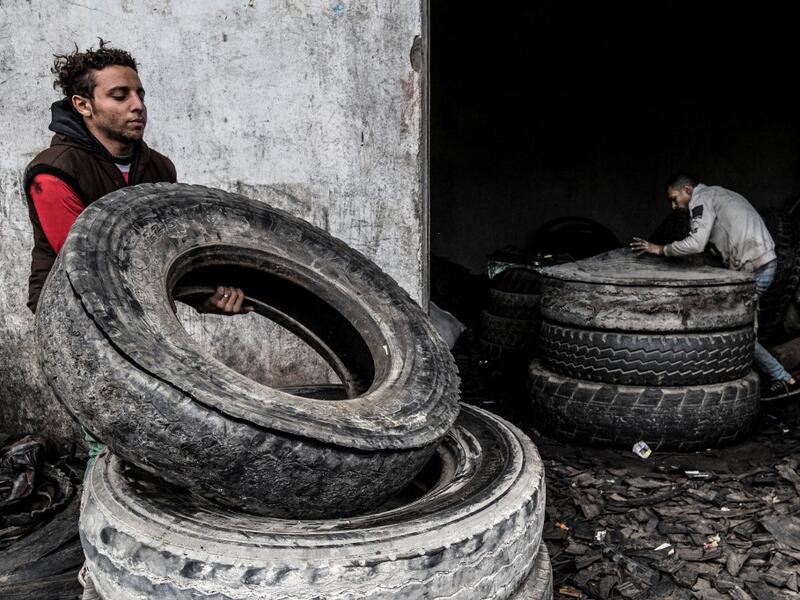 Labourers transport stacked tyres at a rubber recycling workshop in the village of Mit al-Harun in Egypt's central Nile delta Gharbia Governorate, about 70 kilometres (43 miles) north of the capital, on January 14, 2020. Khaled DESOUKI / AFP