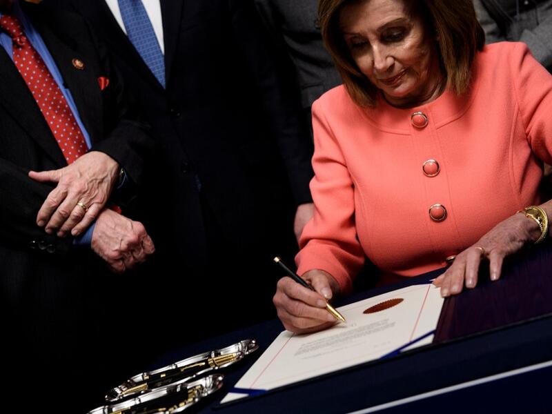 Speaker of the House Nancy Pelosi (D-CA) signs the articles of impeachment of US President Donald Trump during an engrossment ceremony on Capitol Hill January 15, 2020, in Washington, DC. The US House of Representatives voted Wednesday to transmit articles of impeachment against President Donald Trump to the Senate, opening the way for the historic trial of the 45th president for abuse of power. Brendan Smialowski / AFP
