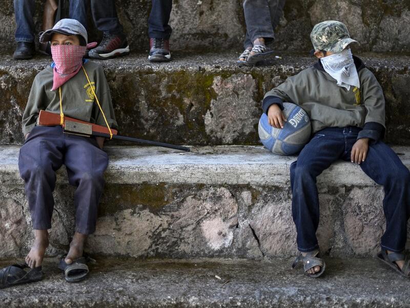 Children are tought to use weapons by the Regional Coordinator of Community Authorities (CRAC-PF) community police force at a basketball court in the village of Ayahualtempan, Guerrero State, Mexico, on January 24, 2020. The CRAC-PF vigilante group trains children as young as five so they can protect themselves from drug-related criminal groups operating in the area. Pedro PARDO / AFP