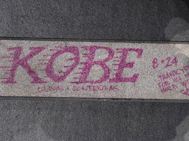 A note is written on the pavement as fans mourn the death of NBA legend Kobe Bryant, who was killed along with his daughter and seven others in a helicopter crash on January 26, at LA Live plaza in front of Staples Center in Los Angeles on January 27, 2020. Federal investigators sifted through the wreckage of the helicopter crash that killed basketball legend Kobe Bryant and eight other people, hoping to find clues to what caused the accident that stunned the world. Robyn Beck / AFP