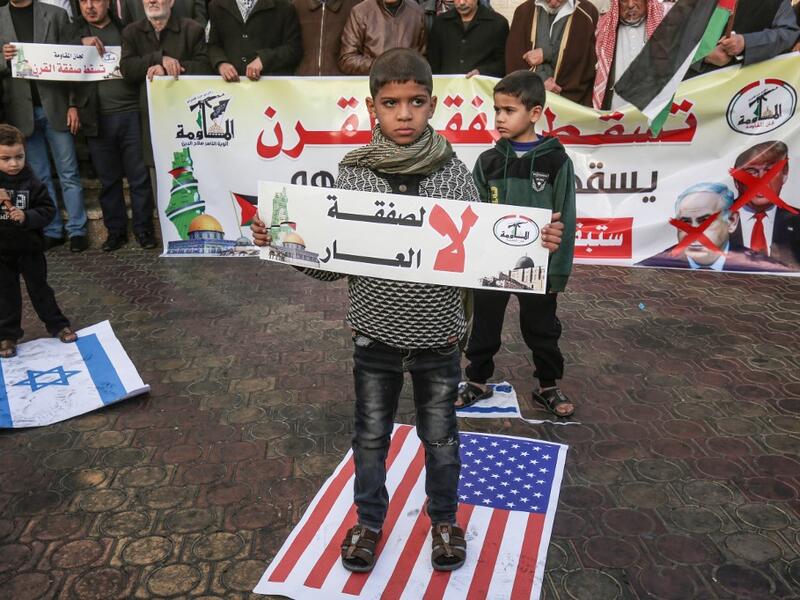 A Palestinian demonstrator takes part in a protest against a US-brokered Middle East peace plan, while holding placard that reads in Arabic "No to the deal of shame", in Rafah in the southern Gaza Strip, on February 1, 2020. SAID KHATIB / AFP