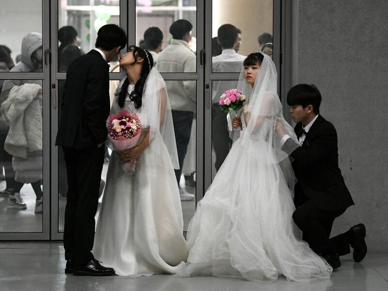 Couples prepare for a mass wedding ceremony organised by the Unification Church at Cheongshim Peace World Center in Gapyeong on February 7, 2020. Thousands of Unification Church couples married at a mass wedding to mark the eighth anniversary of the death of founder and self-proclaimed messiah Sun Myung Moon. Jung Yeon-je / AFP