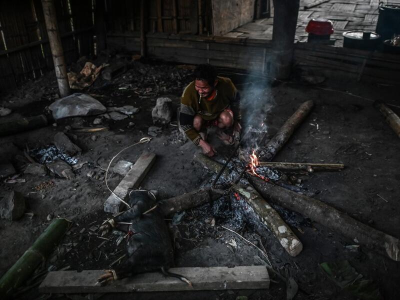 This photo taken on February 7, 2020 shows men preparing a meal after an overnight ceremony by Naga tribeswomen to bless the harvest in Satpalaw Shaung village, Lahe township in Myanmar's Sagaing region. A haunting refrain pierces the night as the tribeswomen of the Gongwang Bonyo, among the most isolated people in Myanmar, dance around a campfire to bless the harvest ahead. Ye Aung THU / AFP