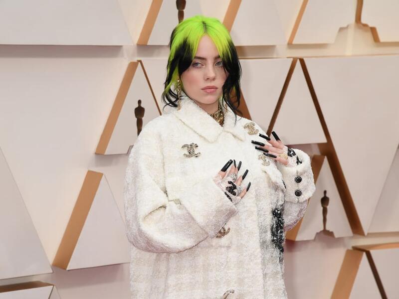 Billie Eilish in a white-on-white houndstooth set, with a jacket featuring the Chanel's interlocking "C" logo