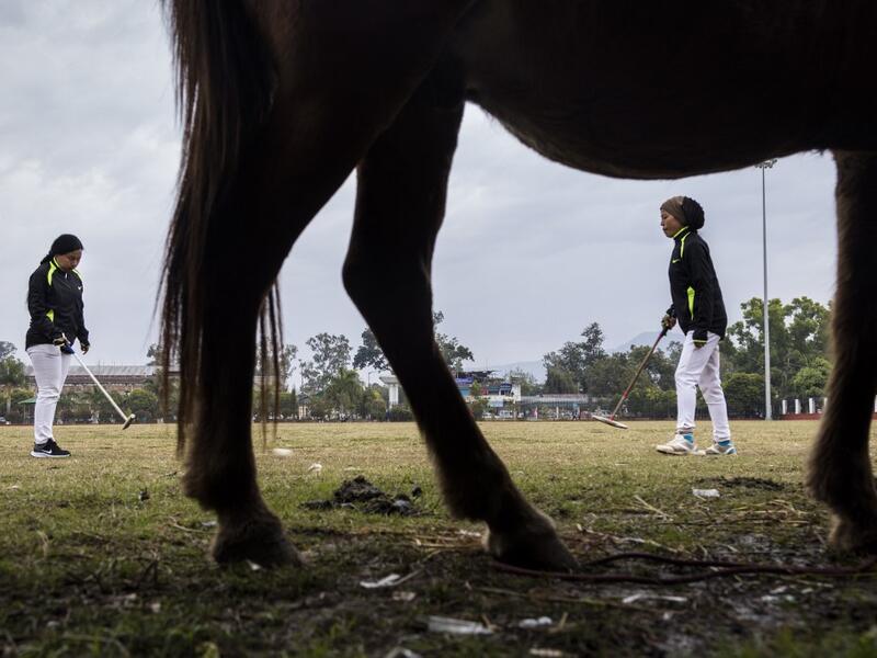 In this photograph taken on January 9, 2020, Linthoingambi Kangjei Lup Polo Club players Shanglenmayum Sangeeta (R) and Okram Ashalucky warm up before the start of their 15th Women's State Polo Tournament match at the Mapal Kangjeibung (Polo Ground) in Imphal, the capital of the northeastern Indian state of Manipur. Laishram Thadoi's face is a picture of concentration as she adjusts her helmet and prepares to play in Manipur, the remote Indian state regarded as the birthplace of modern polo. Xavier GALIANA 