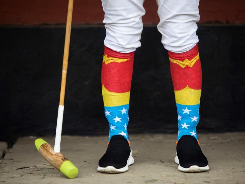 In this photograph taken on January 9, 2020, Linthoingambi Kangjei Lup Polo Club player Khundongbam Dementy, wearing a pair of 'Wonder Woman' socks, follows a match from the sidelines at the Mapal Kangjeibung (Polo Ground) in Imphal, the capital of the northeastern Indian state of Manipur. Laishram Thadoi's face is a picture of concentration as she adjusts her helmet and prepares to play in Manipur, the remote Indian state regarded as the birthplace of modern polo. Xavier GALIANA / AFP