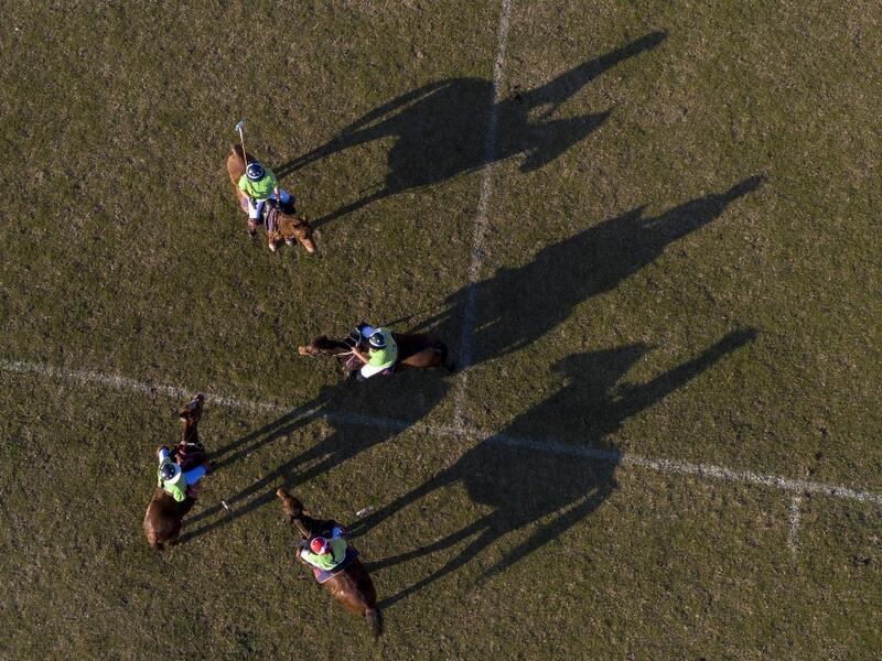 In this aerial photograph taken on January 11, 2020, Linthoingambi Kangjei Lup Polo Club players on their ponies gather on the field during a break of their 15th Women's State Polo Tournament match at the Mapal Kangjeibung (Polo Ground) in Imphal, the capital of the northeastern Indian state of Manipur. Laishram Thadoi's face is a picture of concentration as she adjusts her helmet and prepares to play in Manipur, the remote Indian state regarded as the birthplace of modern polo. Xavier GALIANA / AFP