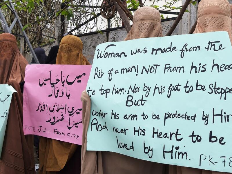 Burqa-clad female activists of Islamic political party Jamiat Ulema-e-Islam (JUI-F), carry placards during a rally to mark the International Women's Day in Peshawar on March 8, 2020. Thousands of people are expected to rally in cities across Pakistan on March 8 to mark International Women's Day in an ultra-conservative society where women are still put to death under ancient "honour" codes. Abdul MAJEED / AFP