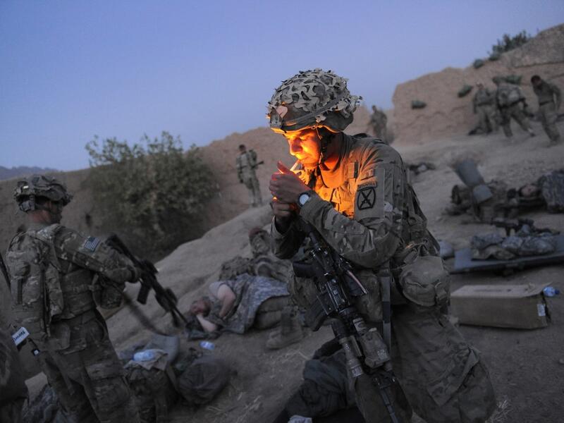 In this file photo taken on August 5, 2011, US soldier Specialist Joshua Schonert from 1st Platoon, Charlie Company, 2-87 Infantry, 3d Brigade Combat Team under Afghanistan's International Security Assistance Force (ISAF), lights a cigarette as he prepares for the day following earlier attacks by Taliban insurgents on their checkpoint in Kandalay village, Kandahar province southern Afghanistan. American forces have started pulling out of two bases in Afghanistan, a US official said on March 10, 2020 the day