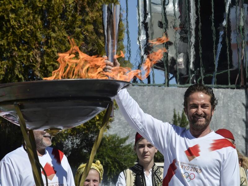 US actor Gerard Butler poses with the Olympic flame during the Olympic flame relay in Sparta on March 13, 2020 ahead of the Tokyo 2020 Olympic Games. Valerie Gache / AFP
