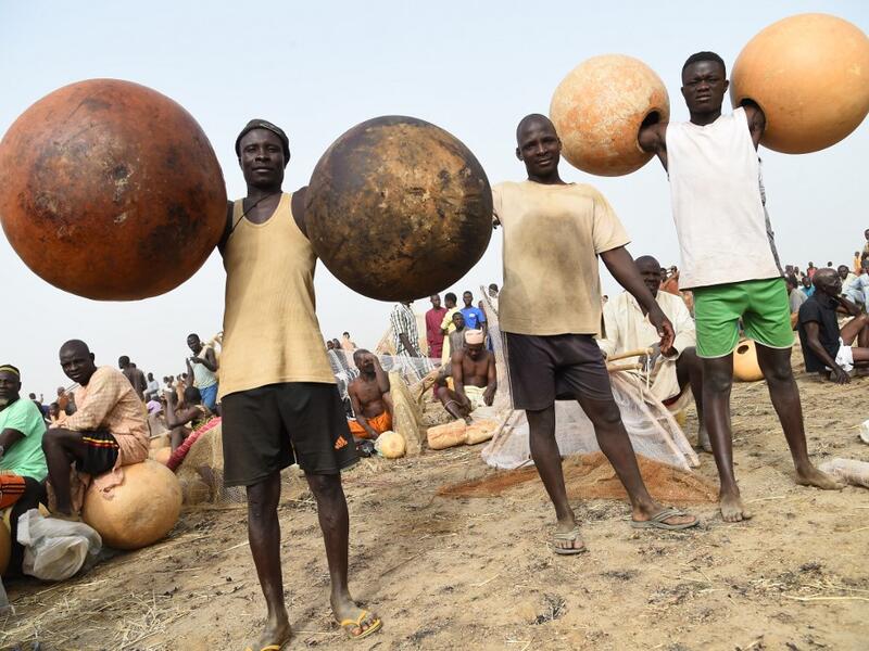 Fishermen carry calabashes to attend Argungu fishing and cultural festival at Argungu Town, Kebbi State in northwestern Nigeria, on March 14, 2020. Argungu fishing and cultural festival is one of the oldest and most widely attended festivals in the country dating back many generations, featuring series of water competitions and traditional games. The festival returned after 10 years suspension due to insecurity in northwest Nigeria. PIUS UTOMI EKPEI / AFP