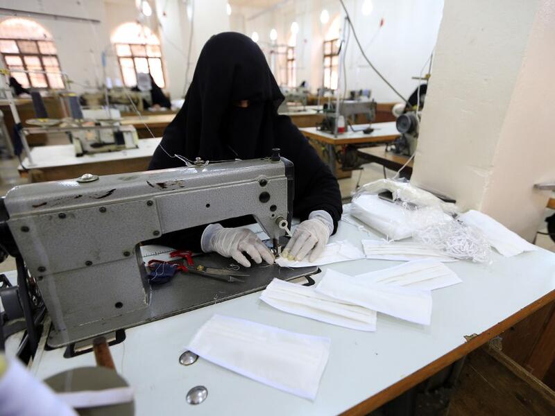A Yemeni woman makes face masks at a textile factory in the capital Sanaa on March 16, 2020. More than a decade after it shut down, 20 women have brought back to life Yemen's oldest industrial factory to manufacture what could save many lives amid a global pandemic: masks. Mohammed HUWAIS / AFP