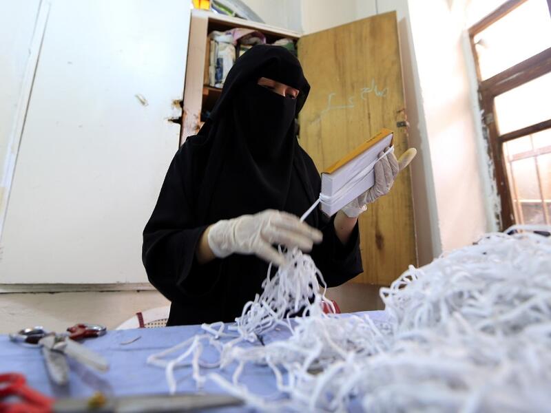 A Yemeni woman makes face masks at a textile factory in the capital Sanaa on March 16, 2020. More than a decade after it shut down, 20 women have brought back to life Yemen's oldest industrial factory to manufacture what could save many lives amid a global pandemic: masks. Mohammed HUWAIS / AFP