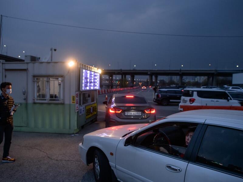 In a photo taken on March 21, 2020 customers queue in their cars to buy tickets at a drive-through cinema in Seoul. Box office numbers in South Korea -- which has 8,897 confirmed virus cases -- have plummeted in recent weeks due to the epidemic, with authorities urging the public to avoid large crowds. But at drive-in cinemas, moviegoers can enjoy a movie from the comfort of their cars, parked in front of a large outdoor screen.  Ed JONES / AFP