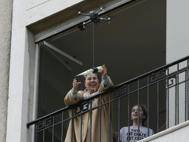 Under lockdown over coronavirus, a drone buzzed towards a balcony on Saturday to deliver a red rose to a mother grinning in surprise. Three students have come up with a new service to celebrate the occasion without social restriction (Twitter)