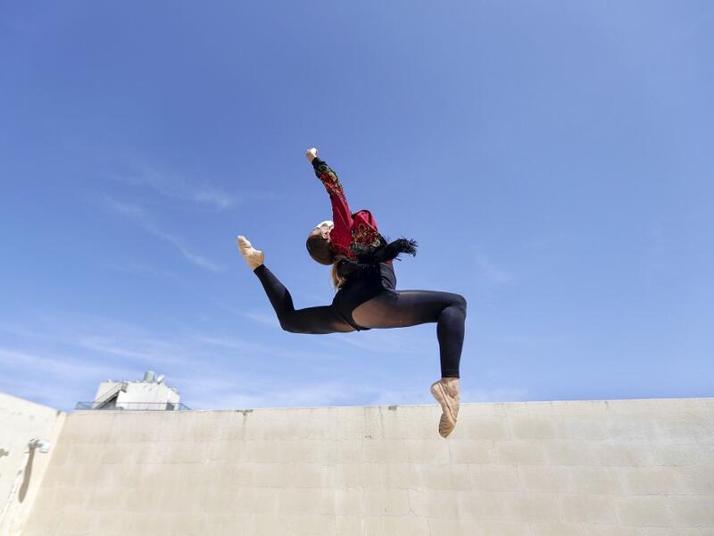 Sherazade Mami, a 28-year-old Tunisian professional dancer and performer at the Caracalla dance theatre and a teacher at the Caracalla dance school, practices while wearing a surgical mask on the roof of her apartment building in the suburb of Dekwaneh on the eastern outskirts of Lebanon's capital Beirut on April 4, 2020. Due to the confinement regulations imposed to combat the COVID-19 coronavirus pandemic, Mami opted to continue practicing on her rooftop to remain in shape. JOSEPH EID / AFP
