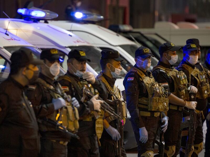 Iraqi security forces wearing protective masks pay tribute to health personnel for their efforts during the coronavirus COVID-19 pandemic crisis, in the southern city of Basra on April 07, 2020. AFP/File
