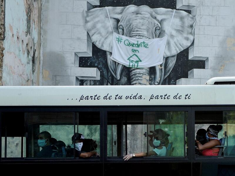 Commuters wear face masks aboard a bus in Havana, on April 11, 2020. Cuba hit out at the United States on Friday over its nearly 60-year-old embargo against the island nation, which Havana described as "even more cruel" given the suffering caused by the new coronavirus pandemic. The communist-run single-party island is finding it tough to source medical supplies and has already recorded 620 coronavirus cases and 16 deaths. YAMIL LAGE / AFP
