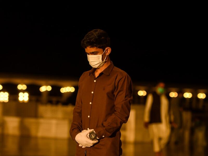 A Muslim wearing facemask and gloves offers a special 'Taraweeh' evening prayer ahead of the first day of the Muslim holy month of Ramadan at the Grand Faisal Mosque in Islamabad on April 24, 2020.  Aamir QURESHI / AFP