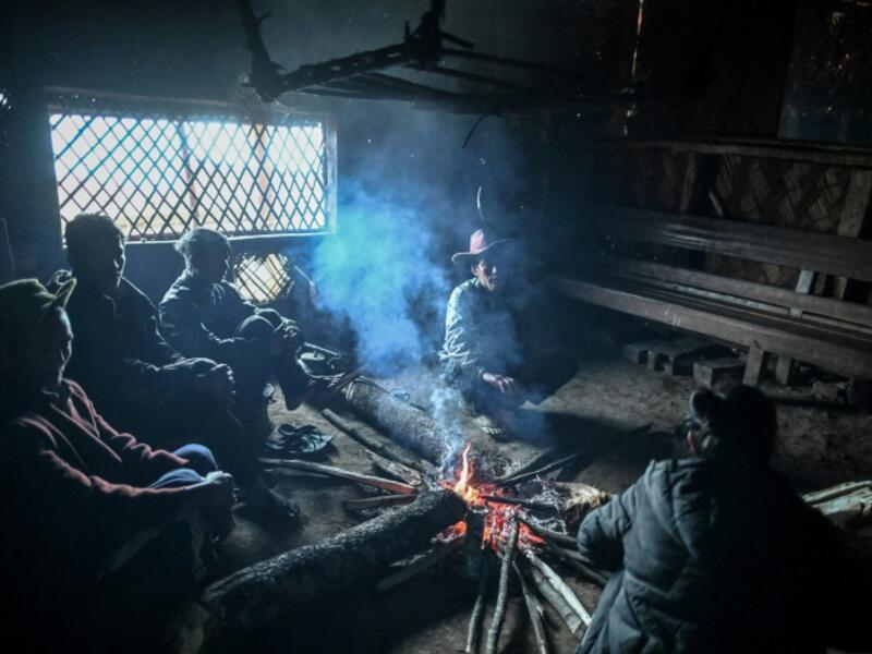 This photo taken on February 9, 2020 shows people resting inside their house in Karmawlawyi village in Myanmar's Sagaing region, near the border with India. The king of the Konyak tribe sleeps in Myanmar, but eats in India -- his house, village and people divided by a mountain border which serves as a vulnerable lifeline now severed by a coronavirus lockdown.  Ye Aung THU / AFP
