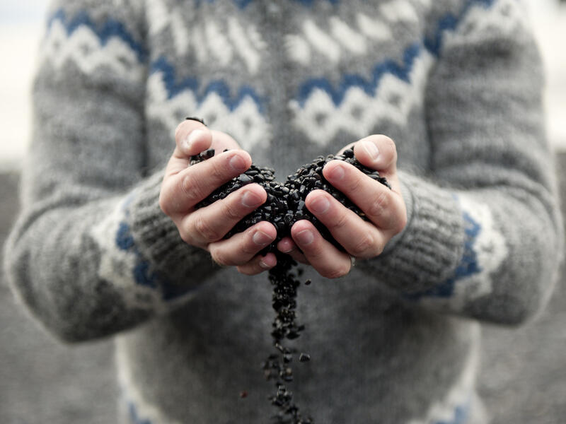 Black sand/rocks falling through fingers on a beach in Vik, Iceland (Shutterstock)