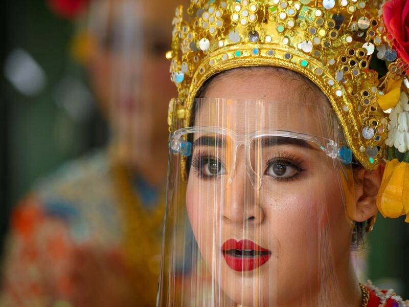 A traditional Thai dancer wearing a protective face shield performs at the Erawan Shrine, which was reopened after the Thai government relaxed measures to combat the spread of the COVID-19 novel coronavirus, in Bangkok on May 4, 2020. Thailand began easing restrictions related to the COVID-19 novel coronavirus on May 3 by allowing various businesses to reopen, but warned that the stricter measures would be re-imposed should cases increase again. Mladen ANTONOV / AFP
