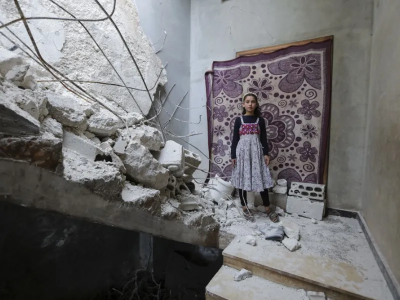 A Syrian girl whose family decided to return home for fear of the COVID-19 pandemic in packed camps for the internally displaced, poses for a picture amid the rubble in her damaged house in al-Nayrab, a village ravaged by pro-government forces bombardment near the M4 strategic highway, in Syria's northwestern Idlib province, on May 3, 2020. Bakr ALKASEM / AFP