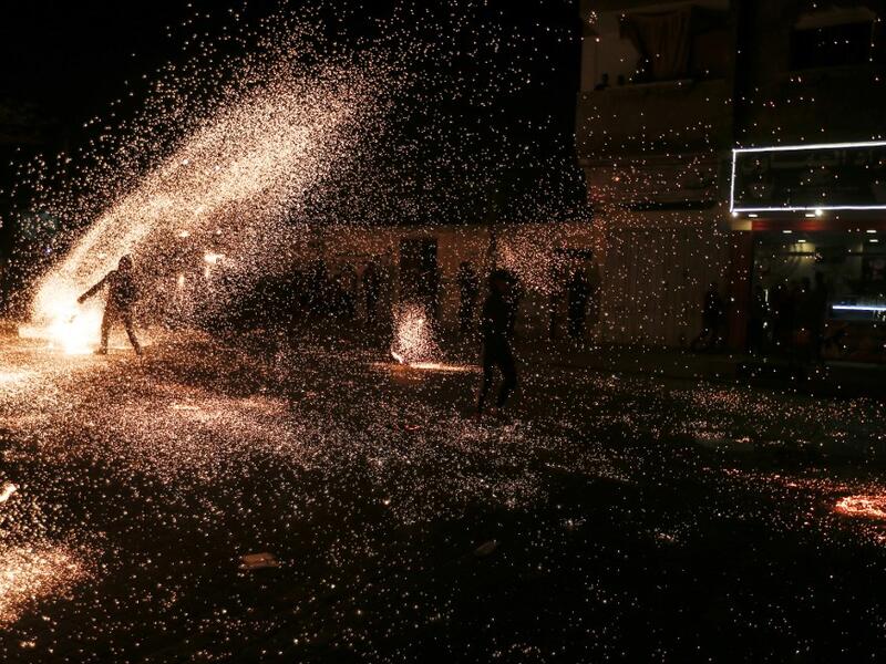 A Palestinian youth swings a homemade sparkler firework as people celebrate on a night of the Muslim holy month of Ramadan in Rafah refugee camp, in the southern Gaza Strip, on May 4, 2020. MAHMUD HAMS / AFP