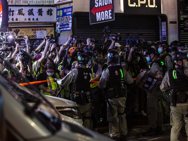Riot police hold back members of the press during a police operation to arrest pro-democracy demonstrators during a protest calling for the city's independence in Mong Kok district of Hong Kong on May 10, 2020. ISAAC LAWRENCE / AFP