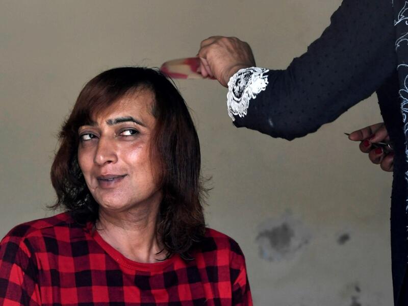 In this picture taken on May 10, 2020, Nadeem Kashish, a member of the transgender community, gets a haircut at a shelter house in Bari Imam neighbourhood of Islamabad. Transgender people in the country are known as "khawajasiras" or "hijras" -- an umbrella term denoting a third sex that includes transgender women and cross-dressers. Pakistan became one of the first countries in the world to legally recognise a third sex in 2009 and began issuing transgender passports from 2017. Aamir QURESHI / AFP