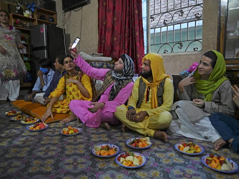 In this picture taken on May 9, 2020, members of the transgenders community gather to break their fast during the Islamic holy month of Ramadan at the Guru transgender house in Rawalpindi. Transgender people in the country are known as "khawajasiras" or "hijras" -- an umbrella term denoting a third sex that includes transgender women and cross-dressers. Pakistan became one of the first countries in the world to legally recognise a third sex in 2009 and began issuing transgender passports from 2017. Aamir QU