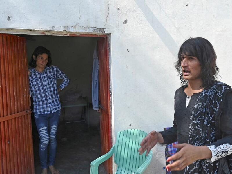 In this picture taken on May 8, 2020, transgenders Adnan Ali (L) and Julie Khan (R) stand outside a shelter house in the Bari Imam neighbourhood of Islamabad. Transgender people in the country are known as "khawajasiras" or "hijras" -- an umbrella term denoting a third sex that includes transgender women and cross-dressers. Pakistan became one of the first countries in the world to legally recognise a third sex in 2009 and began issuing transgender passports from 2017. Aamir QURESHI / AFP