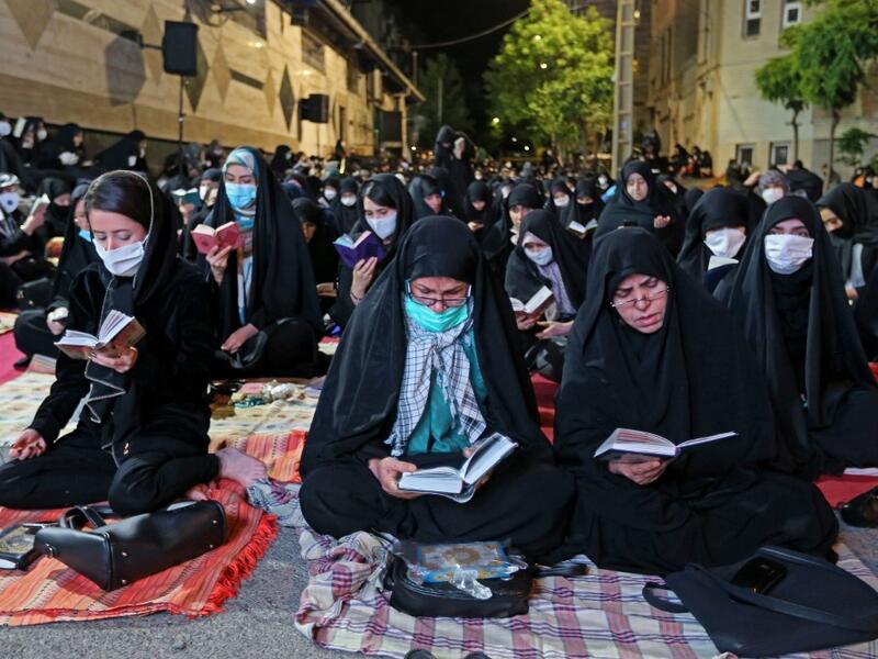Iranians wearing face masks against the Covid-19 coronavirus attend Laylat al-Qadr prayers, one of the holiest nights during the Muslim fasting month of Ramadan, outside a mosque in the Tehran, on May 13, 2020. ATTA KENARE / AFP