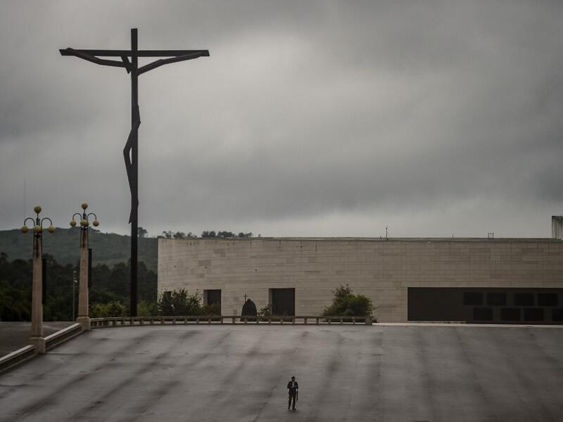 A lone man stands at the Fatima sanctuary during the 103rd anniversary of the apparitions of Our Lady Fatima in central Portugal on May 13, 2020. Without the crowd of pilgrims it welcomes every year, the shrine of Fatima celebrated the anniversary during a religious ceremony reduced to the bare minimum. PATRICIA DE MELO MOREIRA / AFP