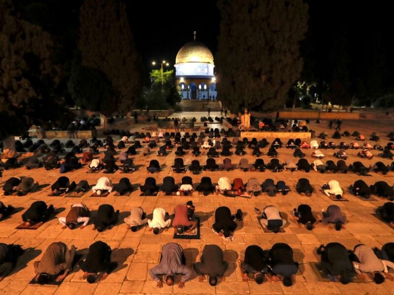 Palestinians perform the dawn prayer (salat al-fajr) inside the al-Aqsa mosque compound, in Jerusalem's Old City on May 31, 2020, after a two-month closure due to the COVID-19 pandemic. AHMAD GHARABLI / AFP