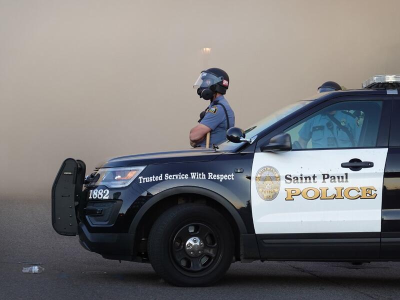 A police officer watches a retail store burn during a protest on May 28, 2020 in St. Paul, Minnesota. Today marks the third day of ongoing protests after the police killing of George Floyd. Four Minneapolis police officers have been fired after a video taken by a bystander was posted on social media showing Floyd's neck being pinned to the ground by an officer as he repeatedly said, "I cant breathe."SCOTT OLSON / GETTY IMAGES NORTH AMERICA / Getty Images via AFP 