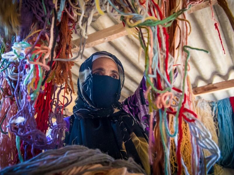 A Moroccan rug weaver sorts out yarn at a workshop in the city of Sale, north of the capital Rabat, on June 3, 2020, during the novel coronavirus pandemic. Artisans in Morocco have been starved of income for almost three months because of the COVID-19 pandemic. The crafts industry represents some seven percent of GDP, with an export turnover last year of nearly 1 billion dirhams ($100 million). FADEL SENNA / AFP
