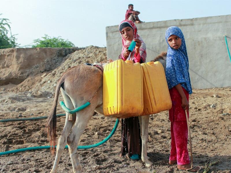 Yemeni girls fill jerrycans carried by donkeys with water from a cistern at a make-shift camp for the internally displaced, in the northern Hajjah province, on June 7, 2020, amid a severe shortage of water. ESSA AHMED / AFP