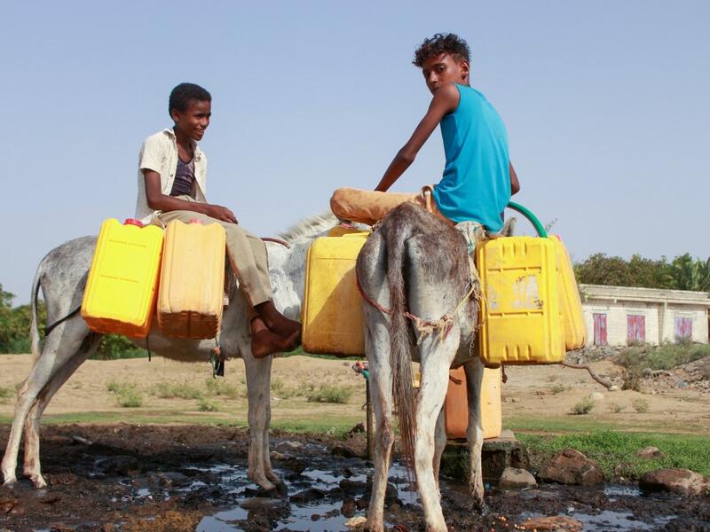 Yemeni children riding donkeys fill their jerrycans with water from a cistern at a make-shift camp for the internally displaced, in the northern Hajjah province, on June 7, 2020, amid a severe shortage of water. ESSA AHMED / AFP