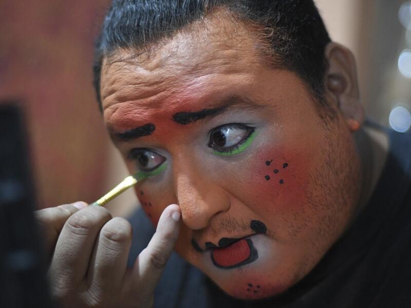 Chimbombita clown puts on make up before taking to the streets to beg for money to survive the crisis caused by the new coronavirus in Villa Nueva, 20 km south Guatemala City, on June 10, 2020, as clowns have been unable to work due to restrictions to prevent the spread of the COVID-19.Johan ORDONEZ / AFP