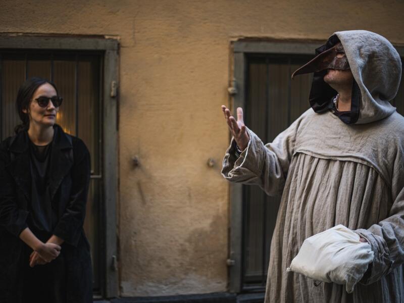 Tour guide Mike Anderson (R) takes visitors on May 30 ,2020 on a 'plague walk', taking them around sites in Stockholm's old town related to pandemics of the plague in the 14th and 18th century, and an outbreak of cholera that hit the city in the mid-19th century. With tourists confined at home and Stockholmers staying away from crowds, one Swedish tour guide is trying to boost his flagging business by offering coronavirus-weary Swedes tours of the city's previous pandemics. AFP