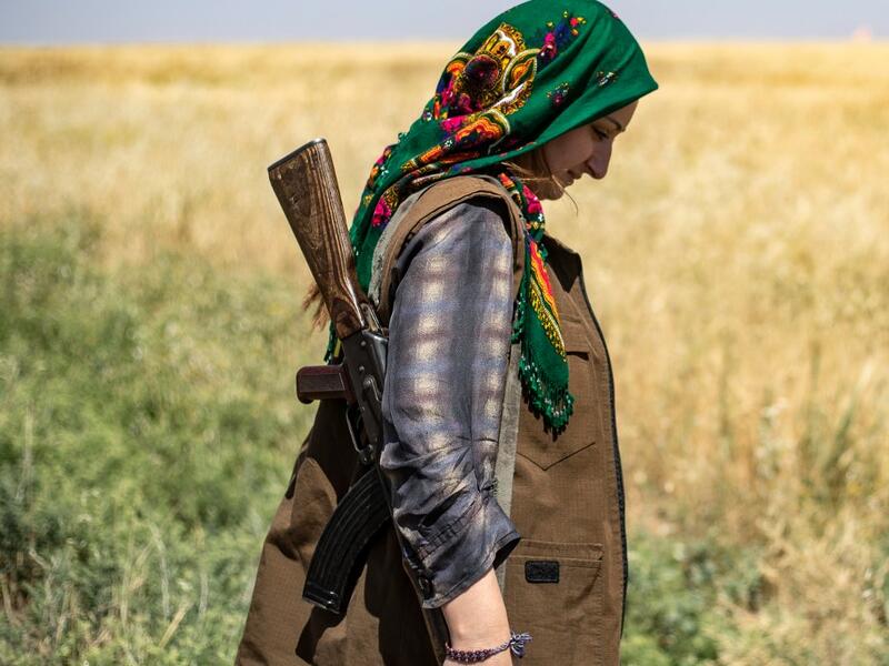 A Kurdish female volunteer, from the newly formed Community Protection Forces, guards a wheat field, against threats by jihadists to burn the crops, during harvest season on June 13, 2020, in the countryside east of Qamishli in Syria's northeastern Hasakah province. Delil SOULEIMAN / AFP