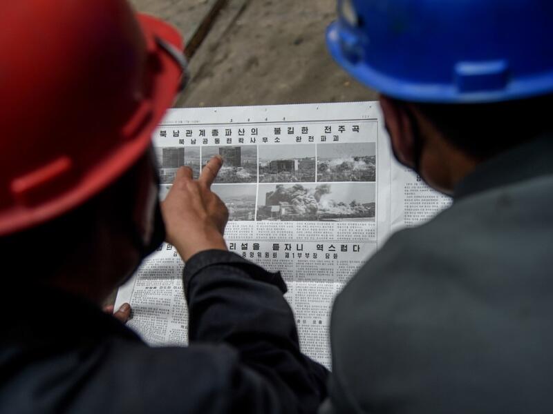 Employees of the Kim Jong Thae Electric Locomotive Complex in Pyongyang read a copy of the Rodong Sinmun newspaper showing coverage of North Korea's demolition of the north-south joint liaison office, on June 17, 2020. North Korea's spectacular destruction of its liaison office with the South is part of a series of staged provocations aimed at forcing concessions from Seoul and Washington, analysts say. KIM Won Jin / AFP