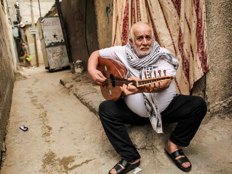 Tawfiq Shanaa, a 66-year-old man, plays the oud as he performs traditional Palestinian songs outside his house in the Rafah camp for Palestinian refugees in the southern Gaza Strip on June 20, 2020. June 20 marks World Refugee Day, a day dedicated by the United Nations General Assembly to raising awareness of the situation of refugees throughout the world. SAID KHATIB / AFP