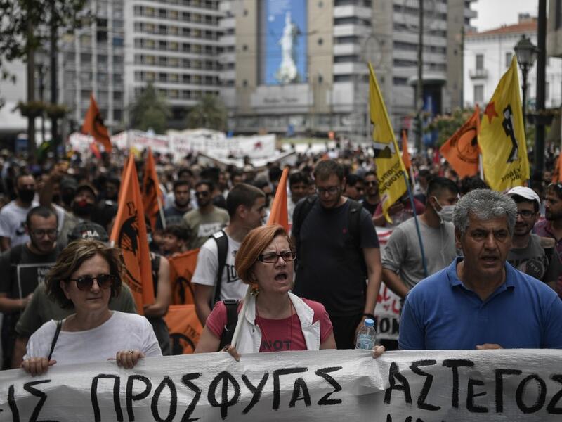 Solidarity groups and NGO's march behind banners as they participate in a rally in Athens on June 20, 2020, marking World Refugee Day as they demand rights and housing for refugees and migrants in Greece. Louisa GOULIAMAKI / AFP