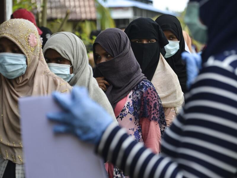Rohingya woman from Myanmar queue up as they go through identification procedures by Indonesian police at the immigration detention centre in Lhokseumawe in Indonesia's North Aceh Regency on June 26, 2020. Nearly 100 Rohingya asylum seekers stranded off the coast of Indonesia were pulled to shore on June 25 by locals angered at the refusal of authorities to give them shelter over coronavirus fears. CHAIDEER MAHYUDDIN / AFP