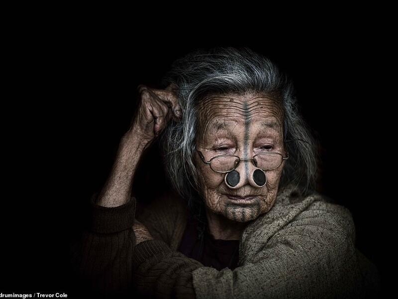 Another woman, also wearing nose plugs, was photographed wearing glasses and more modern modern clothes, suggesting the tribe lost its untouched nature long ago. (Mediadrumimages/ Trevor Cole)